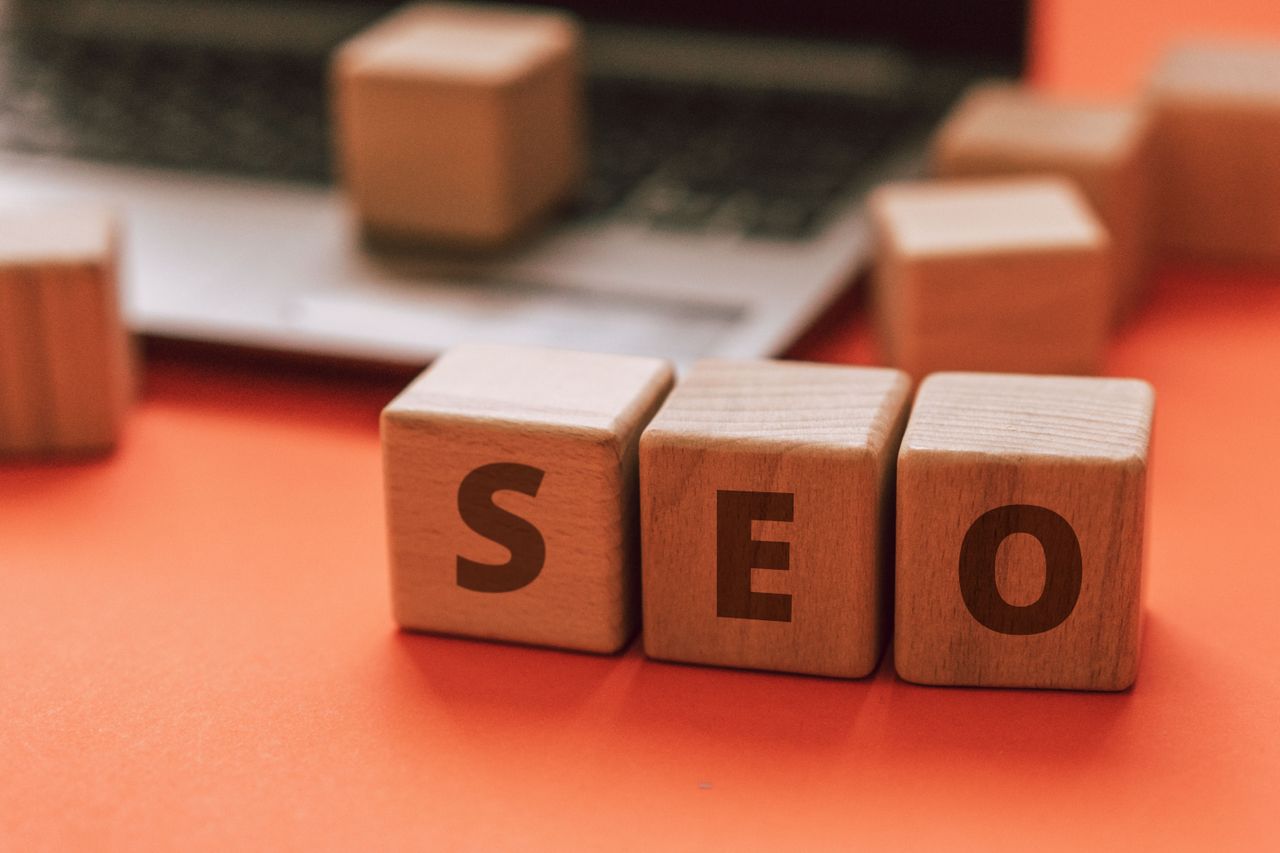 about-01 Wooden blocks spelling SEO on a laptop keyboard convey digital marketing concepts.